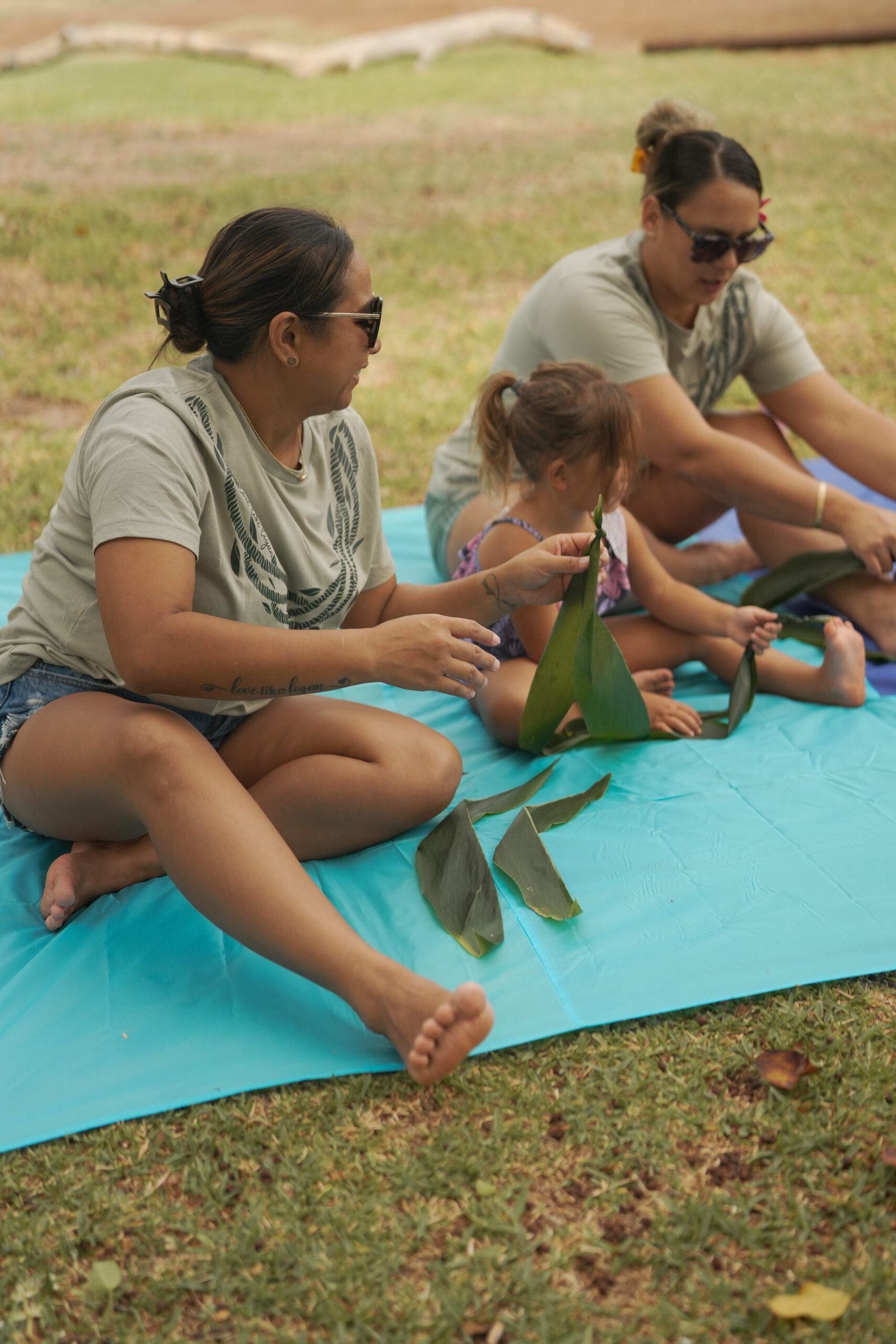 Community members preparing ti leaves together